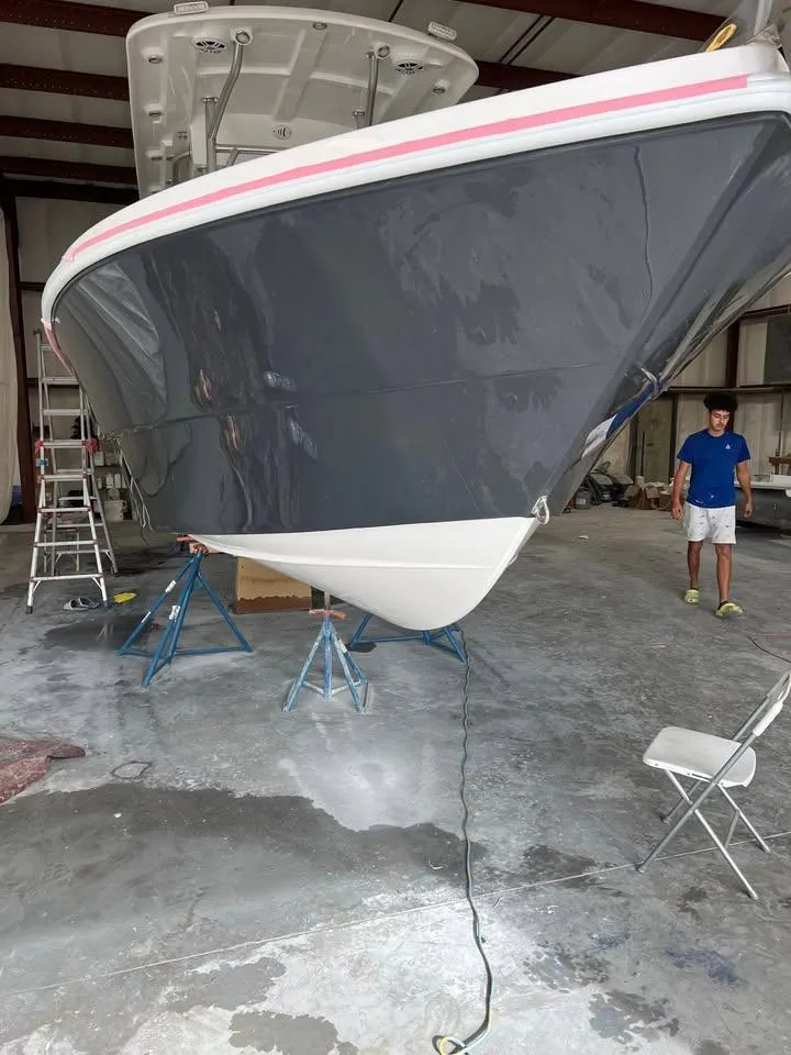 Slide: The Image of Custom Shark Fin R321 boat in a workshop, 2025 model, with a sleek gray hull. - 9