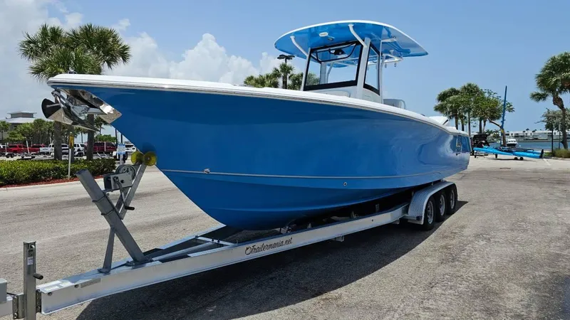 The Image of 2023 Sea Hunt Ultra 305 SE boat on trailer, parked outdoors under clear sky. - 1