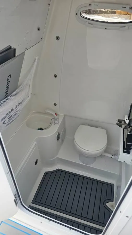 Slide: The Image of 2023 Sea Hunt Ultra 305 SE boat interior with toilet and sink. - 19