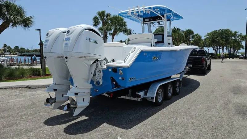 Slide: The Image of 2023 Sea Hunt Ultra 305 SE boat on trailer, featuring dual outboard engines. - 3