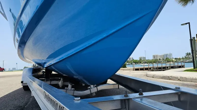 Slide: The Image of 2023 Sea Hunt Ultra 305 SE boat on trailer, blue hull, waterfront background. - 4