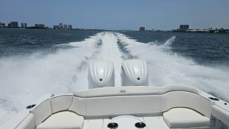 Slide: The Image of 2023 Sea Hunt Ultra 305 SE boat cruising on open water, leaving a wake behind. - 5