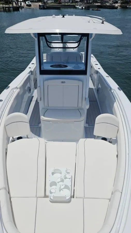 Slide: The Image of 2023 Sea Hunt Ultra 305 SE boat with spacious seating and sleek design on the water. - 6