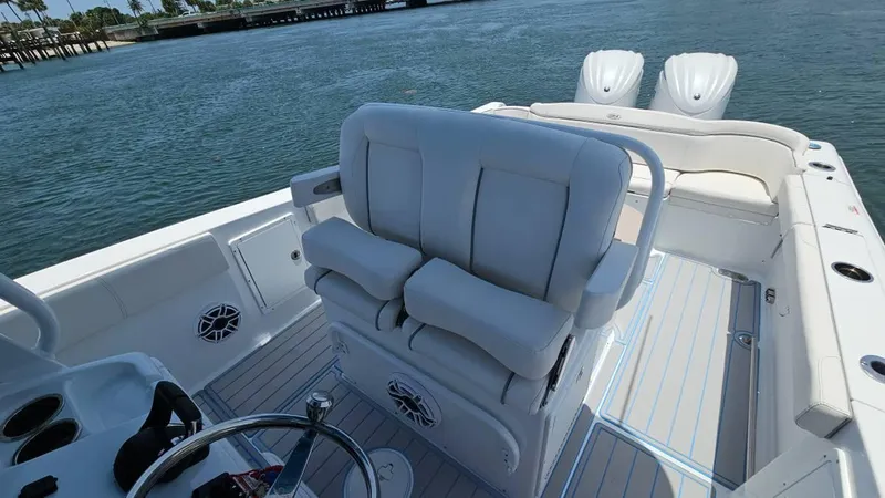 Slide: The Image of 2023 Sea Hunt Ultra 305 SE boat interior with plush seating and dual engines. - 9