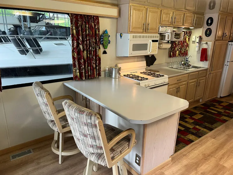 Slide: The Image of Houseboat kitchen interior with wooden cabinets, bar seating, and appliances, Fun Country 56 Forever 10, 1996. - 16