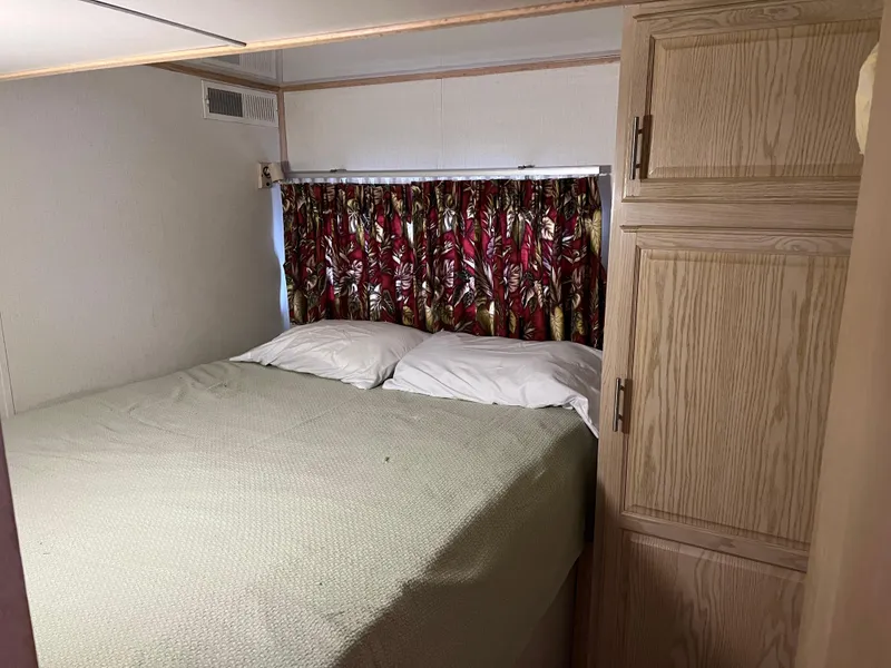 Slide: The Image of Cozy bedroom in 1996 Fun Country houseboat with floral curtains and wooden cabinets. - 18