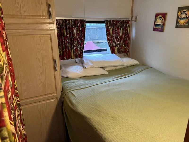 Slide: The Image of Cozy bedroom in 1996 Fun Country houseboat with floral curtains and wooden cabinet. - 19