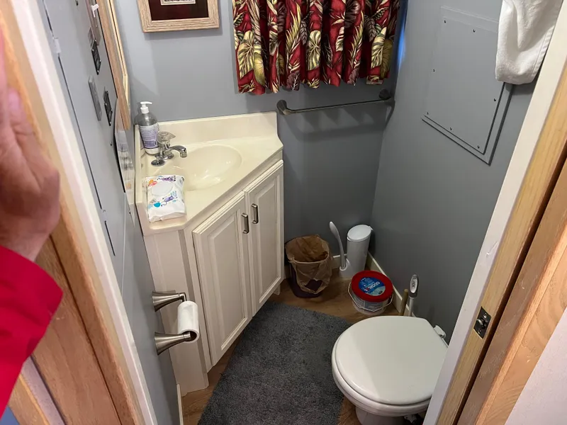 Slide: The Image of Compact bathroom in 1996 Fun Country houseboat with sink, toilet, and floral curtains. - 22