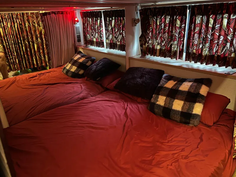Slide: The Image of Cozy bedroom in 1996 Fun Country houseboat with red bedding and patterned curtains. - 23