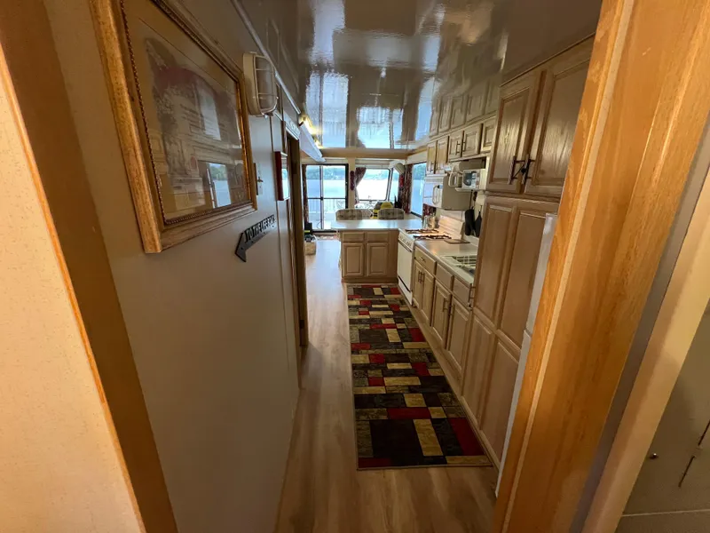 Slide: The Image of Interior of 1996 Fun Country houseboat with wooden cabinets and colorful rug. - 26