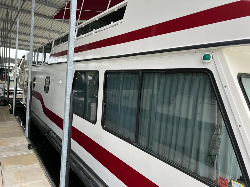 Slide: The Image of 1996 Fun Country 56 Forever 10 House Boat docked under a covered marina. - 6