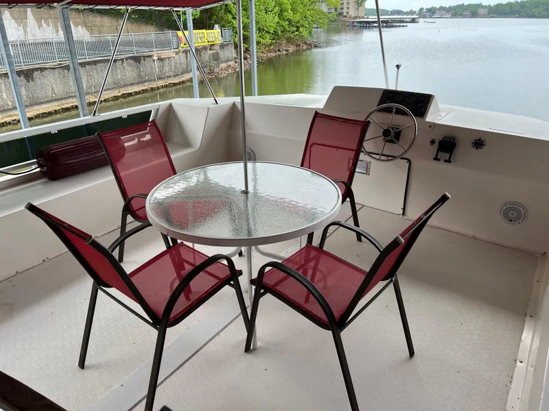 Slide: The Image of Houseboat deck with red chairs and glass table, overlooking serene water. Fun Country 56 Forever 10, 1996. - 8