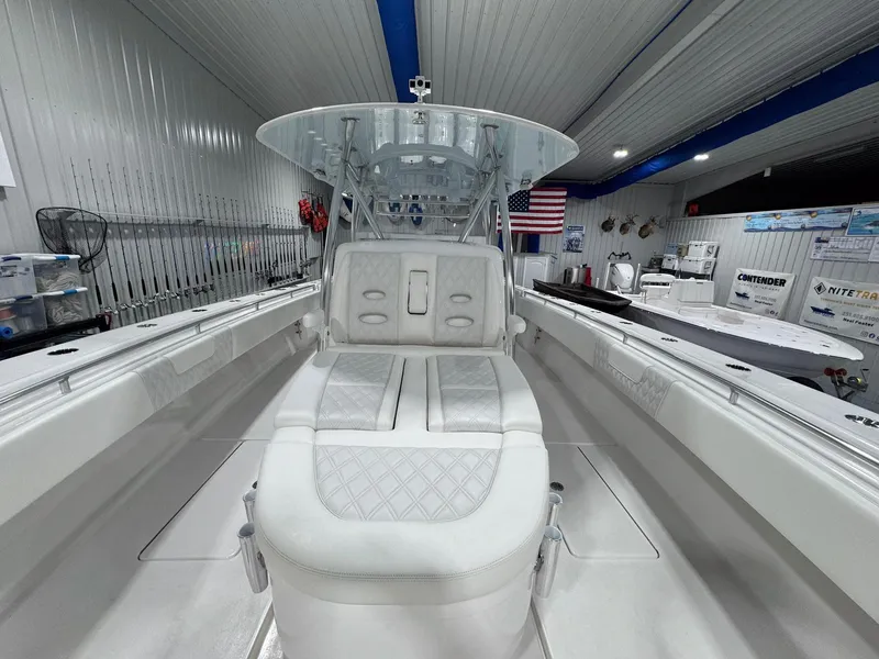 Slide: The Image of 2024 Contender 44 ST boat interior with sleek seating and modern design in a showroom. - 12