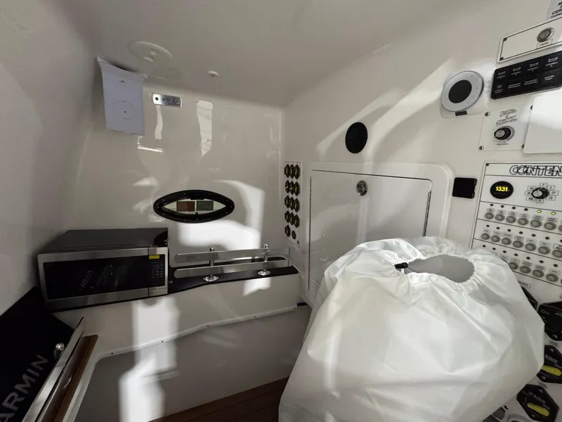 Slide: The Image of 2024 Contender 44 ST interior with microwave, control panel, and storage compartment. - 28