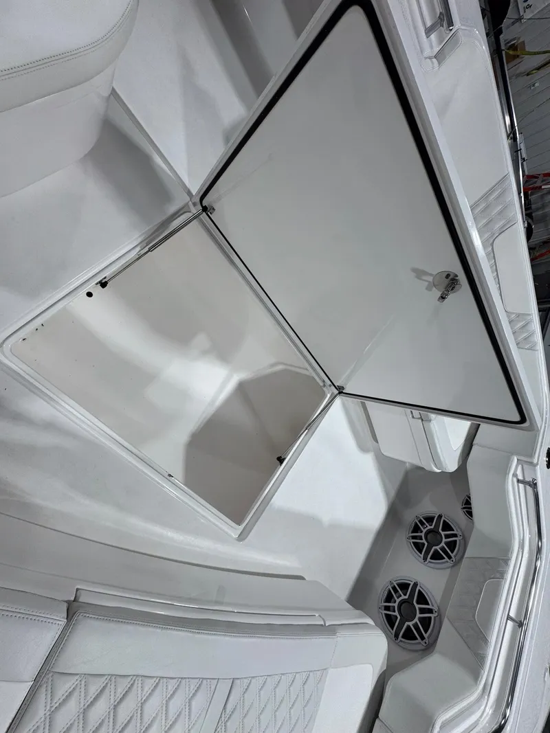 Slide: The Image of 2024 Contender 44 ST boat interior with open storage compartment and speaker system. - 33