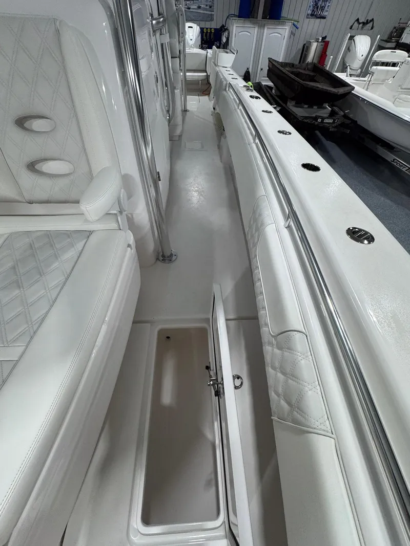 Slide: The Image of 2024 Contender 44 ST boat interior with white seating and open storage compartment. - 34