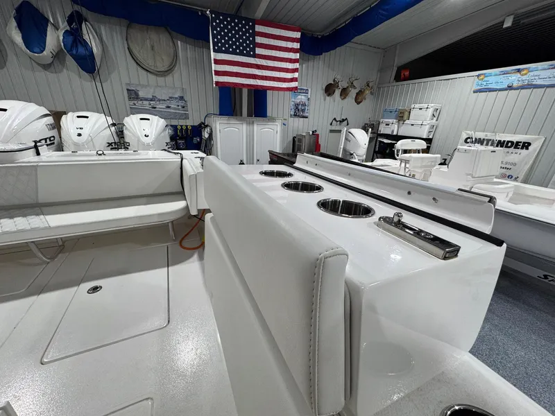 Slide: The Image of 2024 Contender 44 ST boat interior with seating, rod holders, and American flag in showroom. - 37