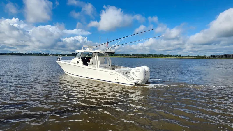 Slide: The Image of 2023 Pursuit S 358 Sport boat cruising on a calm river under a blue sky. - 10