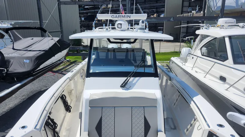 Slide: The Image of 2023 Pursuit S 358 Sport boat docked, featuring Garmin equipment and sleek design. - 20