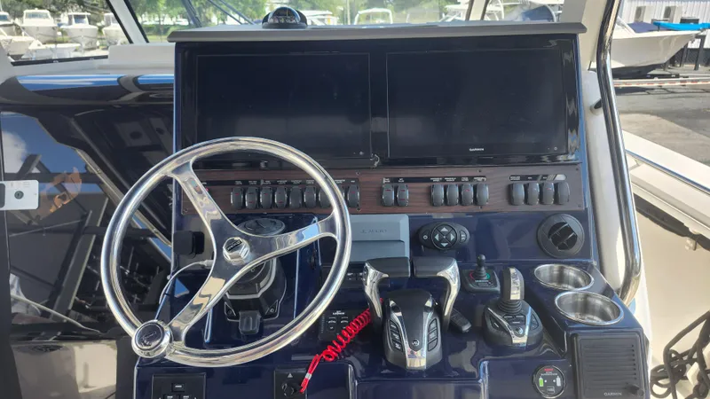 Slide: The Image of 2023 Pursuit S 358 Sport boat dashboard with steering wheel and controls. - 28
