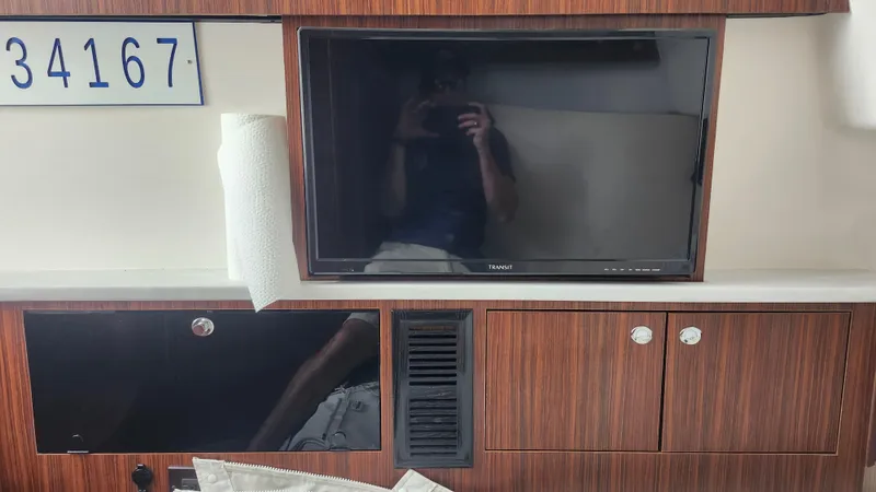 Slide: The Image of 2023 Pursuit S 358 Sport interior with TV, wood paneling, and storage cabinets. - 32