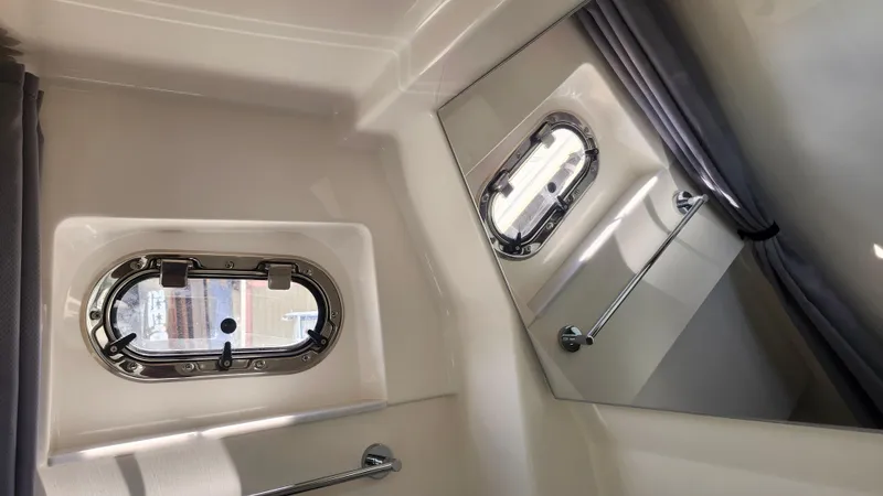 Slide: The Image of 2023 Pursuit S 358 Sport boat interior with porthole and curtain. - 35