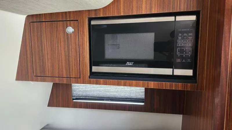 Slide: The Image of 2023 Pursuit S 358 Sport interior with wood paneling and built-in microwave. - 36