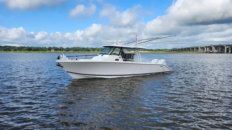 Slide: The Image of 2023 Pursuit S 358 Sport boat on calm water under a blue sky. - 4