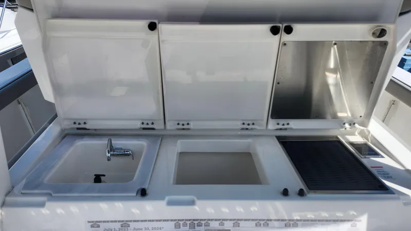 Slide: The Image of 2023 Pursuit S 358 Sport boat kitchen area with sink and storage compartments. - 42