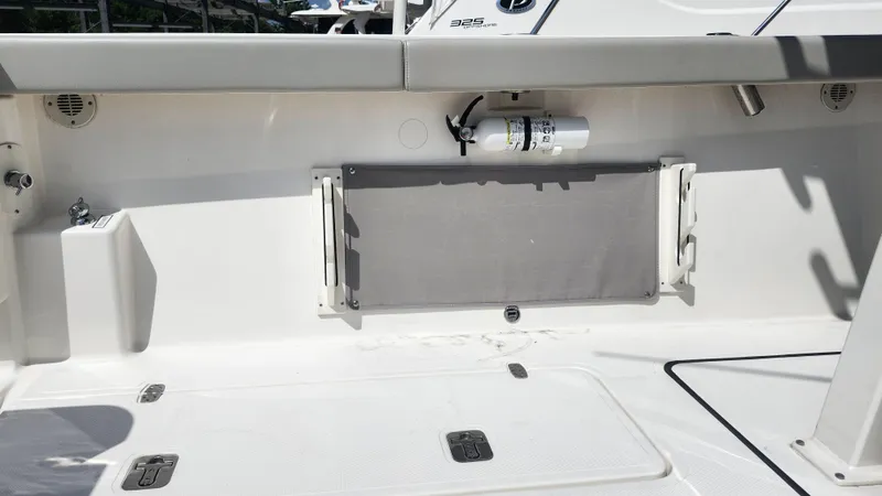 Slide: The Image of 2023 Pursuit S 358 Sport boat interior with storage compartment and fire extinguisher. - 48