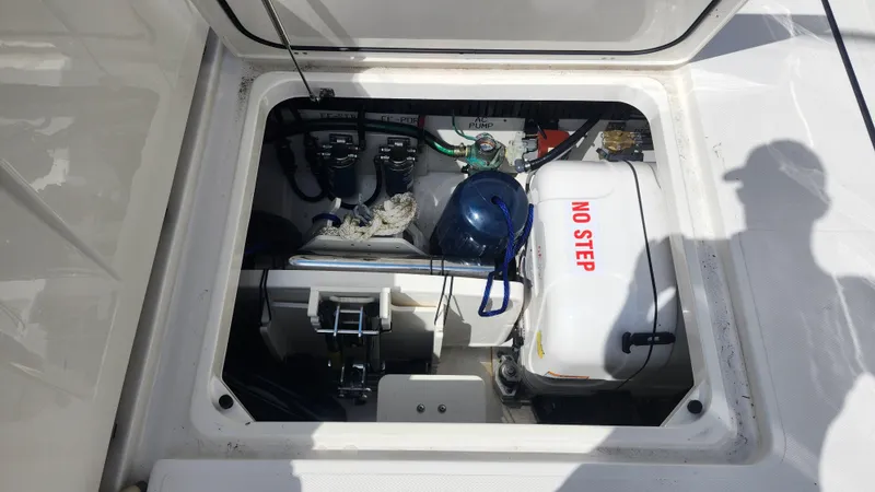 Slide: The Image of 2023 Pursuit S 358 Sport boat compartment with equipment and "No Step" warning label. - 49