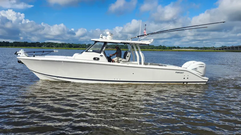 Slide: The Image of 2023 Pursuit S 358 Sport boat cruising on a calm river under a blue sky. - 7