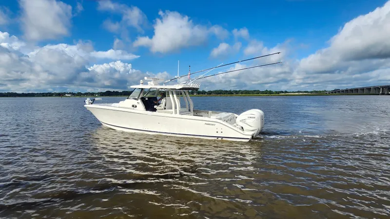 Slide: The Image of 2023 Pursuit S 358 Sport boat cruising on a calm river under a blue sky. - 9
