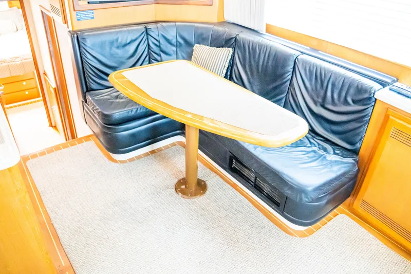 Slide: The Image of Luxurious 2002 Cabo 47 Flybridge Sportfisher interior with leather seating and wooden table. - 19