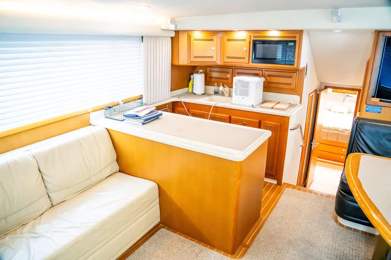 Slide: The Image of Luxurious interior of 2002 Cabo 47 Flybridge Sportfisher with kitchen and seating area. - 21
