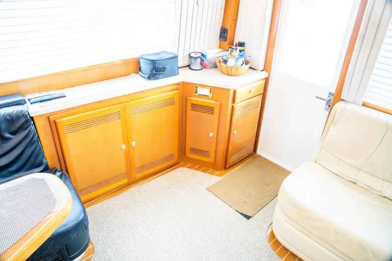 Slide: The Image of Interior of 2002 Cabo 47 Flybridge Sportfisher with wooden cabinets and seating. - 23