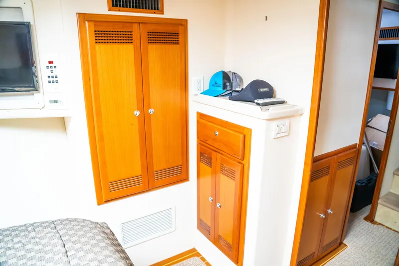 Slide: The Image of Interior of 2002 Cabo 47 Flybridge Sportfisher with wooden cabinets and control panel. - 25