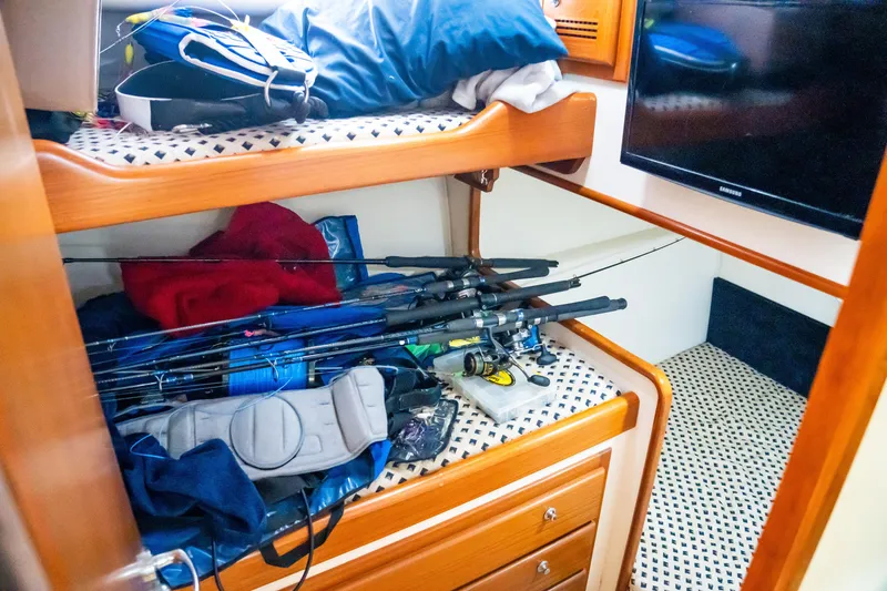 Slide: The Image of Interior of 2002 Cabo 47 Flybridge Sportfisher with fishing gear and bunk beds. - 26