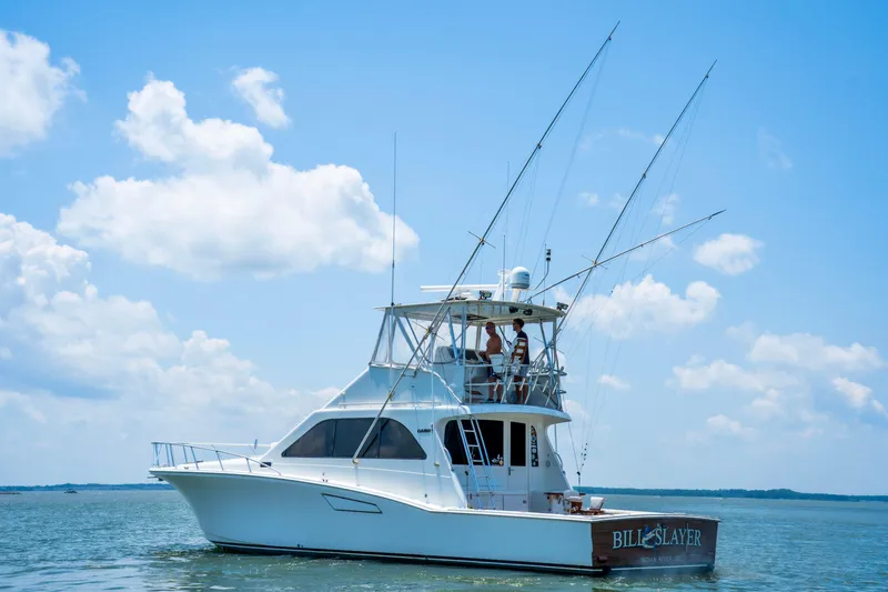 Slide: The Image of 2002 Cabo 47 Flybridge Sportfisher on calm water under a clear blue sky. - 5