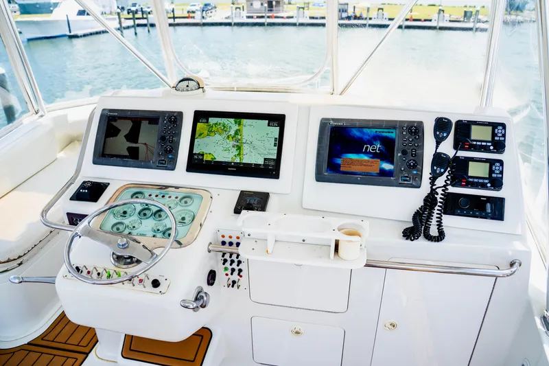 Slide: The Image of Helm of 2002 Cabo 47 Flybridge Sportfisher with navigation screens and controls. - 8
