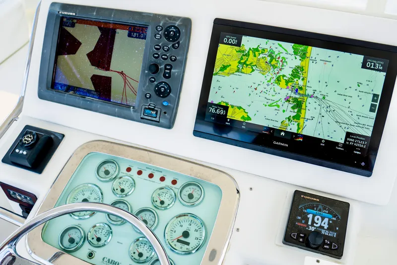 Slide: The Image of Helm of 2002 Cabo 47 Flybridge Sportfisher with navigation displays and gauges. - 9