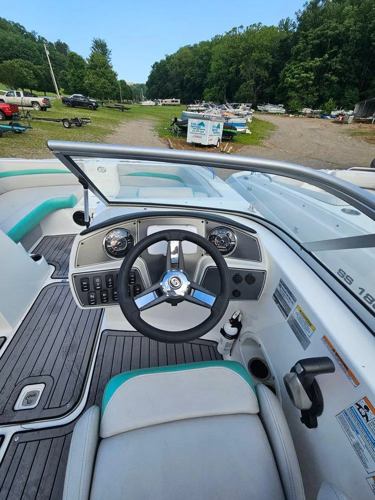 Slide: The Image of 2024 Hurricane SD 191 OB boat dashboard with steering wheel and controls, parked outdoors. - 7
