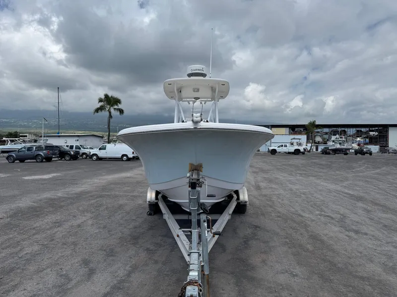 Slide: The Image of 2014 Tidewater 230 LXF boat on trailer in a marina parking lot under cloudy skies. - 10
