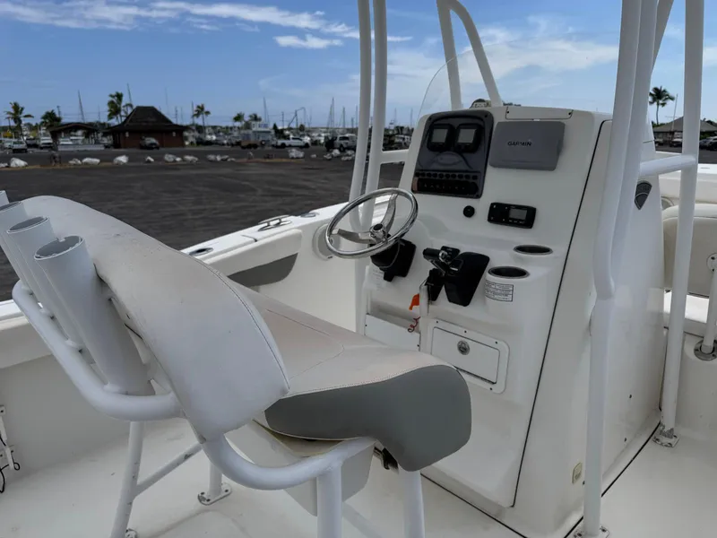 Slide: The Image of 2014 Tidewater 230 LXF boat console with steering wheel and controls, docked at marina. - 14
