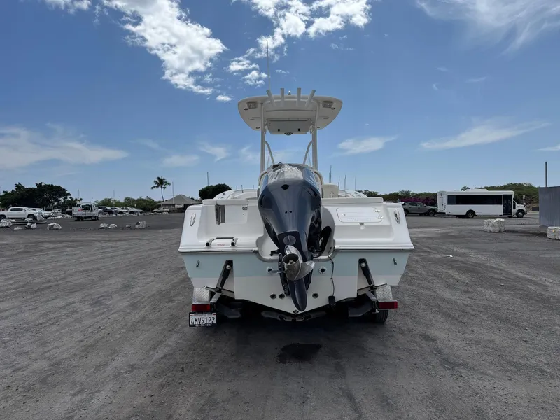 Slide: The Image of 2014 Tidewater 230 LXF boat on trailer, parked under a clear blue sky. - 6