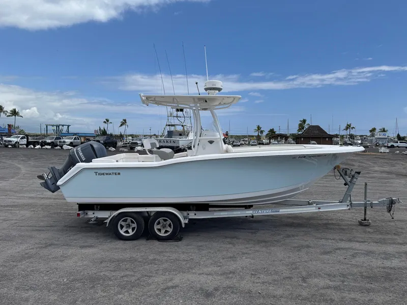 Slide: The Image of 2014 Tidewater 230 LXF boat on trailer, parked in marina under blue sky. - 8