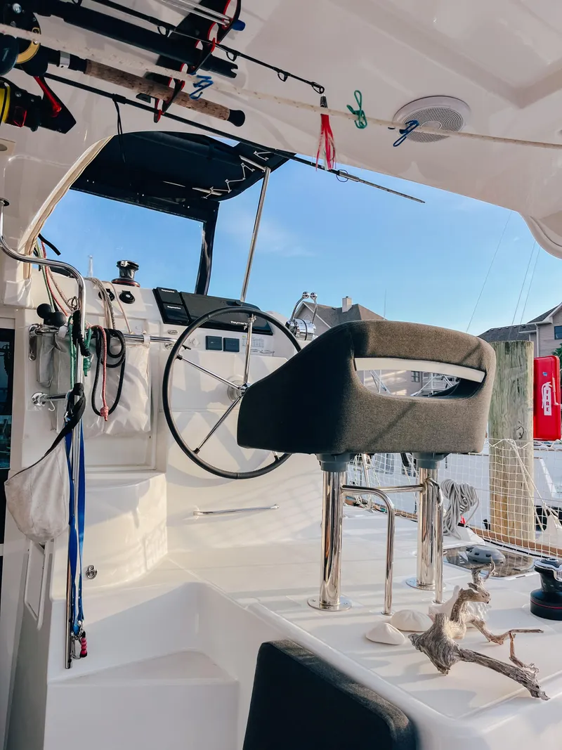 Slide: The Image of Cockpit of 2023 Lagoon 40 catamaran with steering wheel and fishing gear. - 11