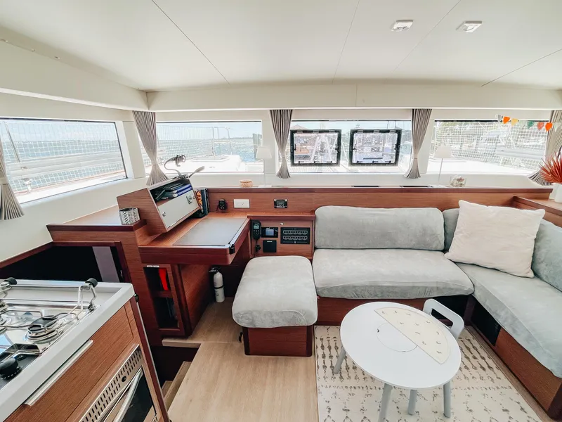 Slide: The Image of Interior of 2023 Lagoon 40 catamaran with modern seating and navigation area. - 12