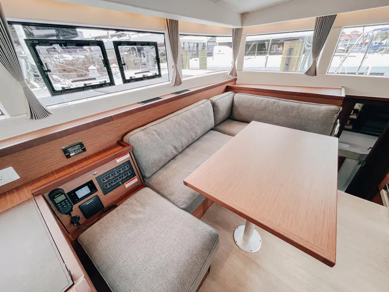 Slide: The Image of Interior of 2023 Lagoon 40 catamaran with cozy seating and wooden table. - 18