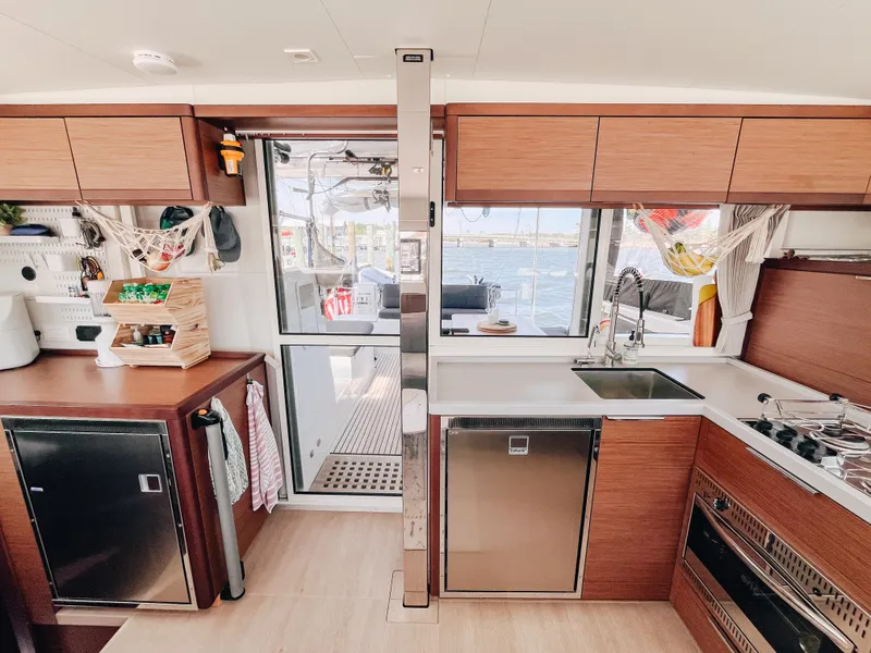 Slide: The Image of Modern kitchen interior of 2023 Lagoon 40 catamaran with wood cabinetry and stainless steel appliances. - 22